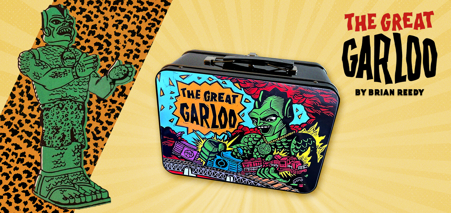 The Great Garloo original green drawing appears next to a black metal lunch box with The Great Garloo on the front of the lunch box.